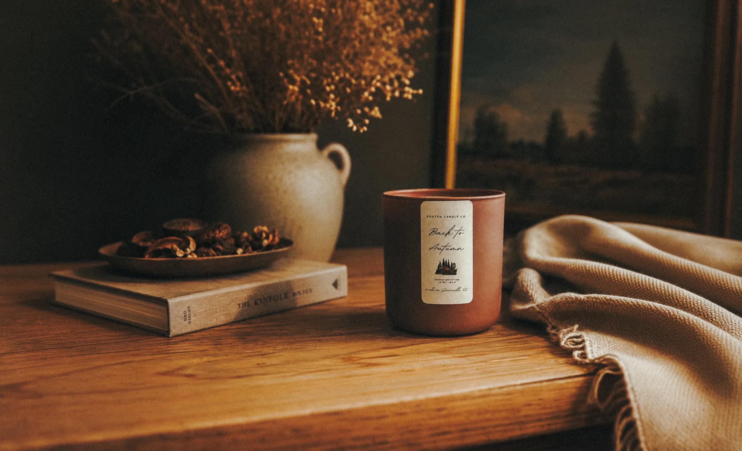 Back to Autumn candle on a wooden table with knit throw and dried florals