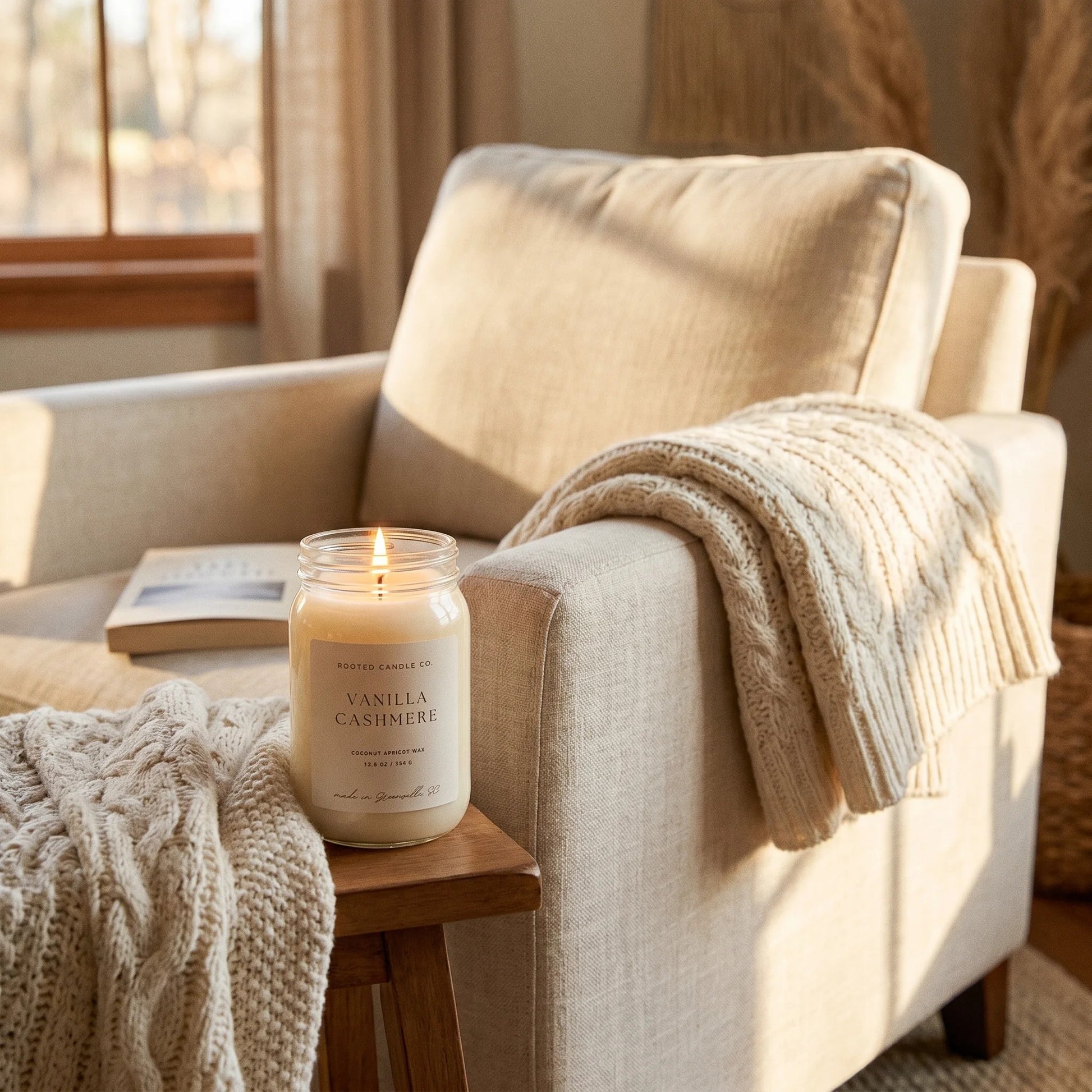 Vanilla Cashmere candle on side table beside knit-throw armchair